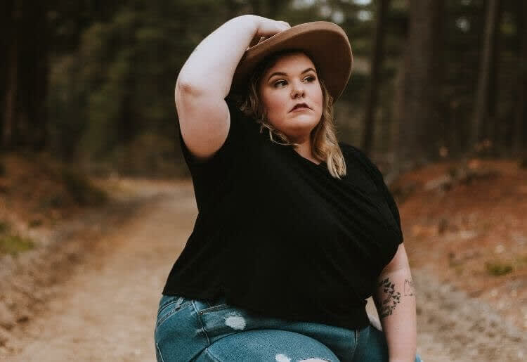 Woman in a forest wearing a hat